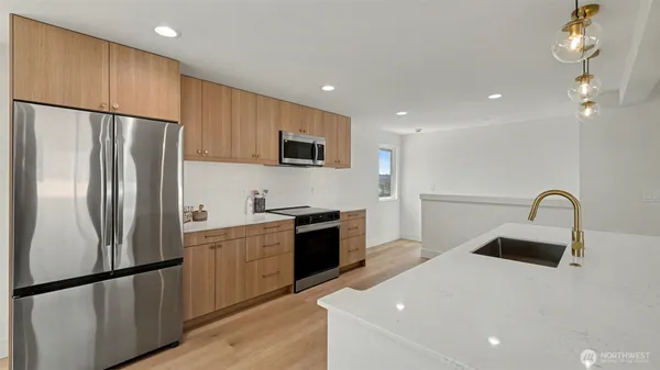 a kitchen with stainless steel appliances a refrigerator sink and microwave