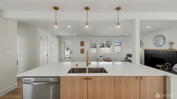 a kitchen with a stove a refrigerator a sink and chairs