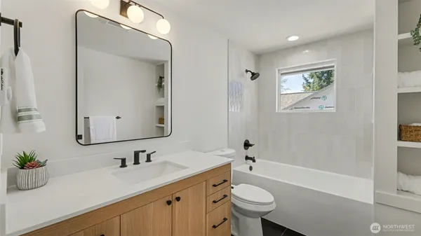 a bathroom with a sink a toilet a mirror and shower