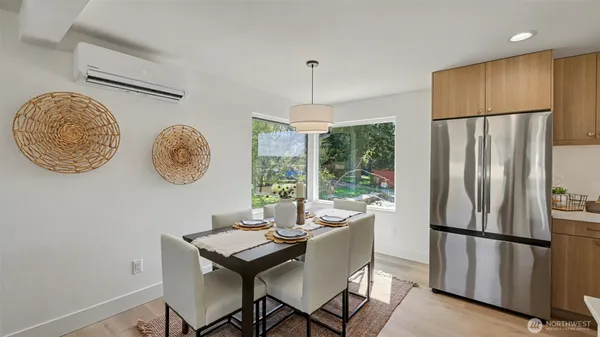 a kitchen with stainless steel appliances granite countertop a dining table chairs in it and wooden floors