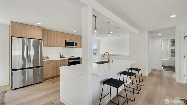 a kitchen with stainless steel appliances a refrigerator and a stove top oven