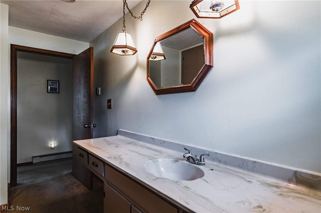 279 Spence Road Belpre, OH 45714 - Photo 19 of 40 Bathroom featuring a textured ceiling, a baseboard radiator, and large vanity