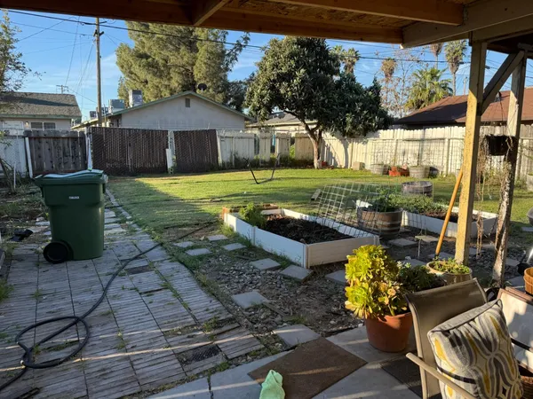 a view of a house with backyard sitting area and garden
