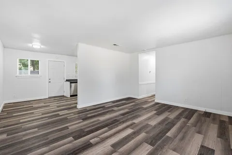 a view of a livingroom with wooden floor and window