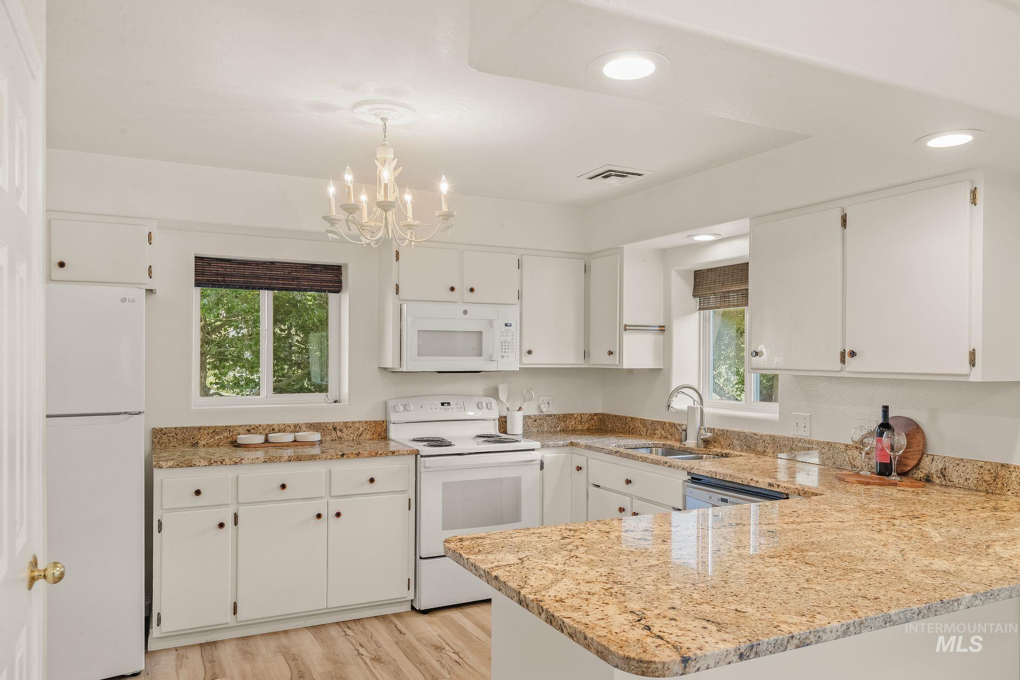 1091 Cedar Ridge Road Kendrick, ID 83537 - Photo 33 of 48 Kitchen featuring granite countertops, wood-finish flooring, white cabinetry, recessed lighting, and a white appliance suite