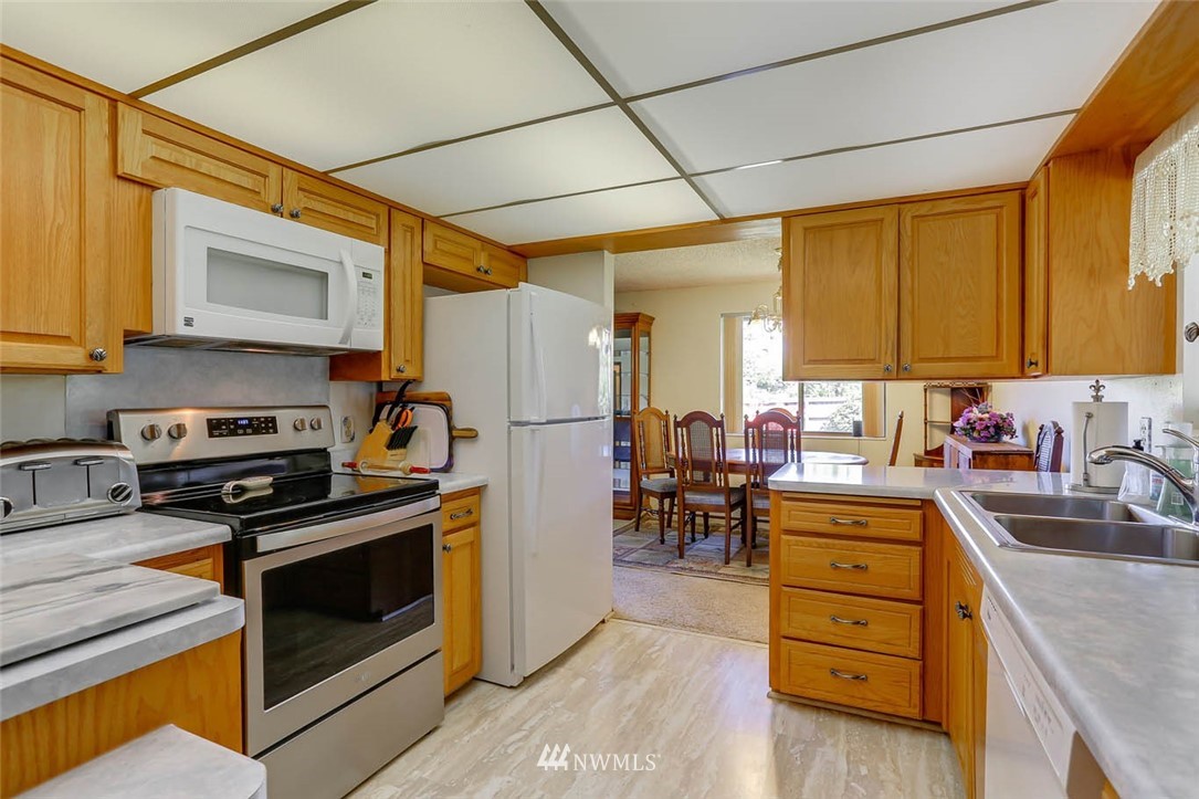 4518 Southeast 2nd Street Renton, WA 98059 - Photo 12 of 29 a kitchen with stainless steel appliances a stove a sink and a refrigerator