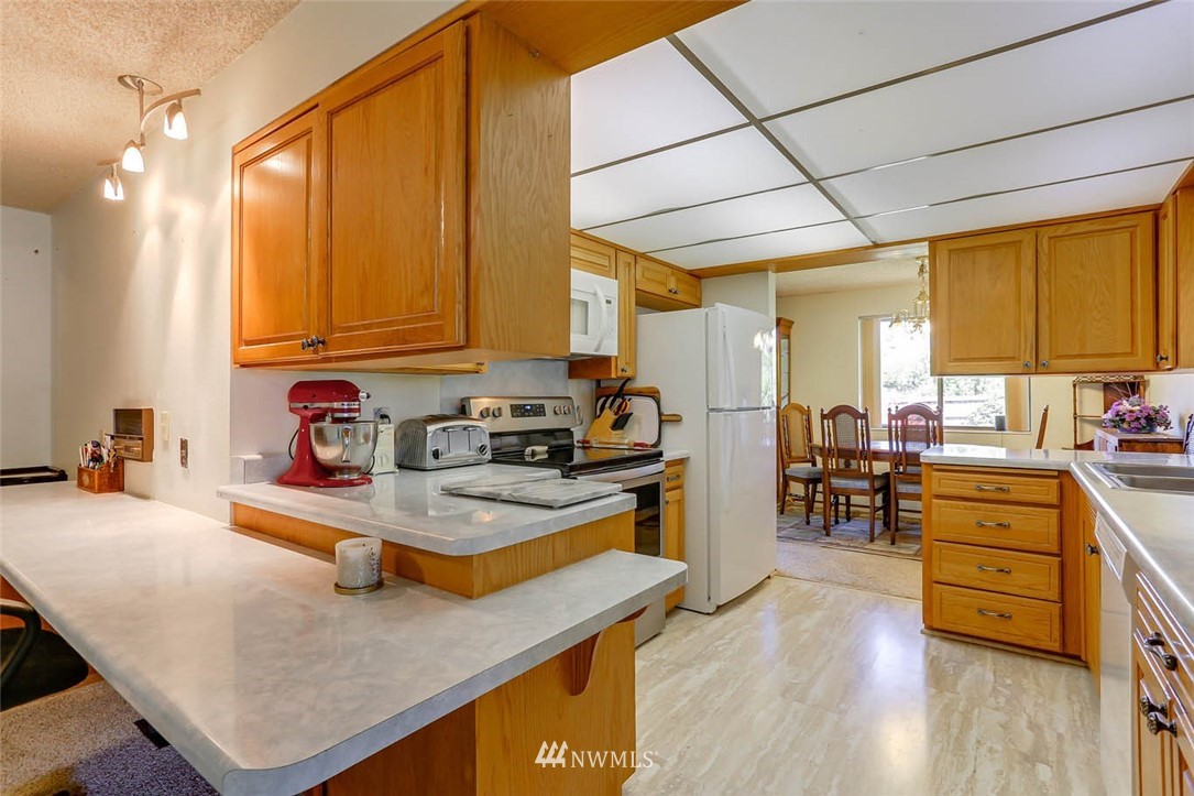 4518 Southeast 2nd Street Renton, WA 98059 - Photo 13 of 29 a kitchen with stainless steel appliances granite countertop wooden cabinets a stove top oven a sink and dishwasher
