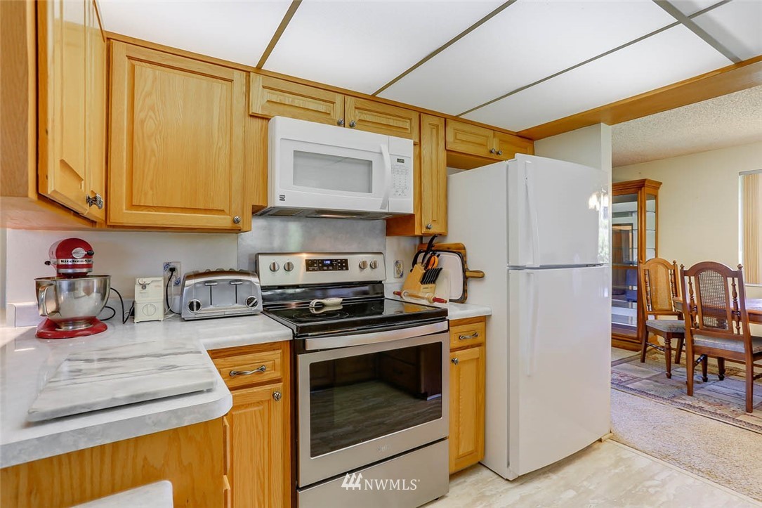 4518 Southeast 2nd Street Renton, WA 98059 - Photo 14 of 29 a kitchen with stainless steel appliances granite countertop a refrigerator and a stove top oven