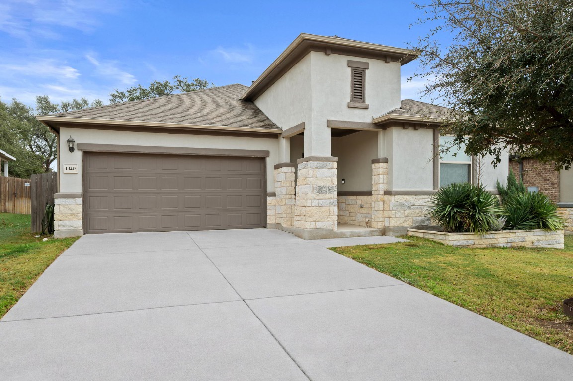 a front view of a house with a yard and garage