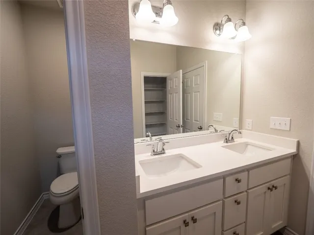 a bathroom with a sink toilet and a mirror