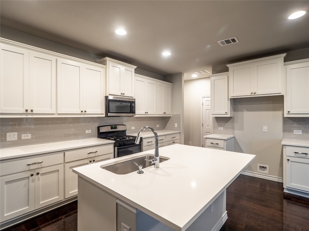 1320 Eagle Ray Street Leander, TX 78641 - Photo 8 of 30 a kitchen with stainless steel appliances a sink a stove a refrigerator and cabinets