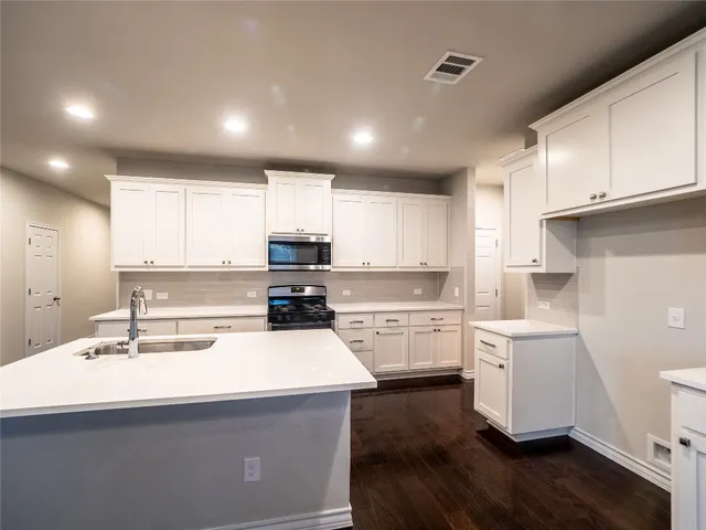a kitchen with a sink a stove and cabinets