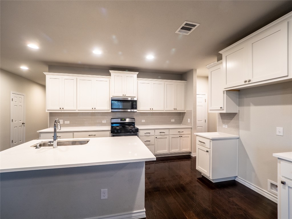 1320 Eagle Ray Street Leander, TX 78641 - Photo 9 of 30 a kitchen with a sink a stove and cabinets