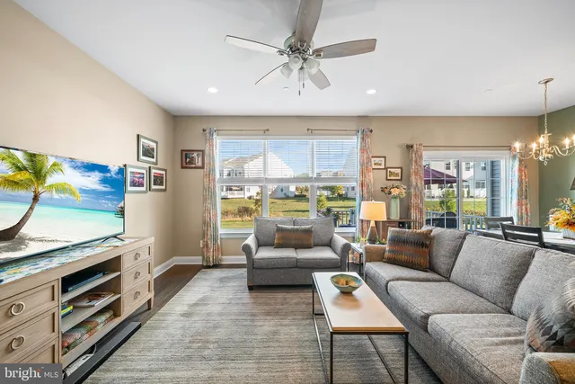 a living room with furniture kitchen view and a wooden floor