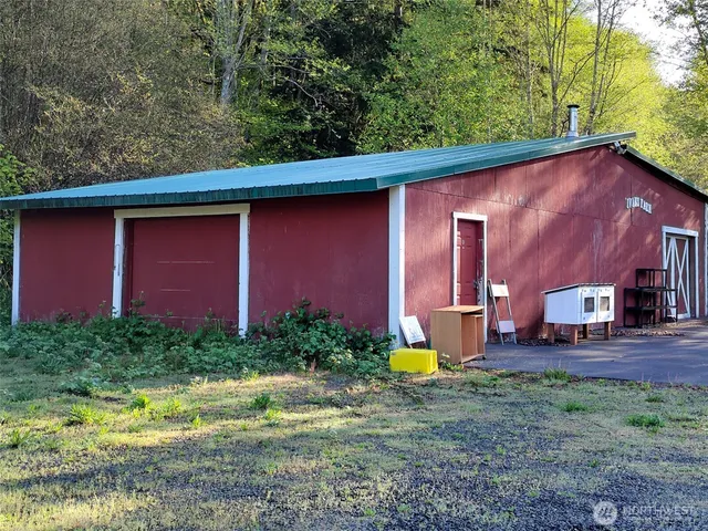 a view of a backyard with plants and a small barn