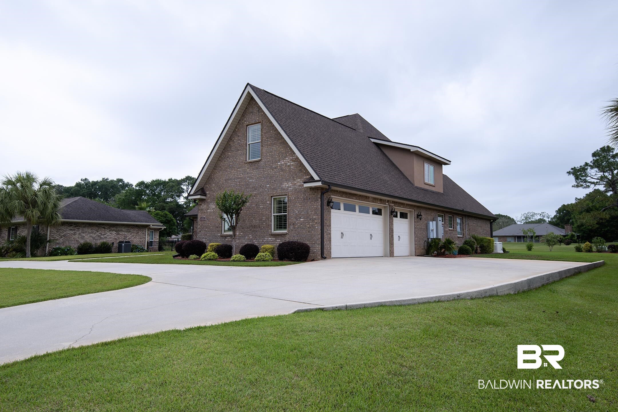 9357 Lakeview Drive Foley, AL 36535 - Photo 3 of 68 Brick exterior featuring a two-car garage with white doors, dormer window, and a concrete driveway