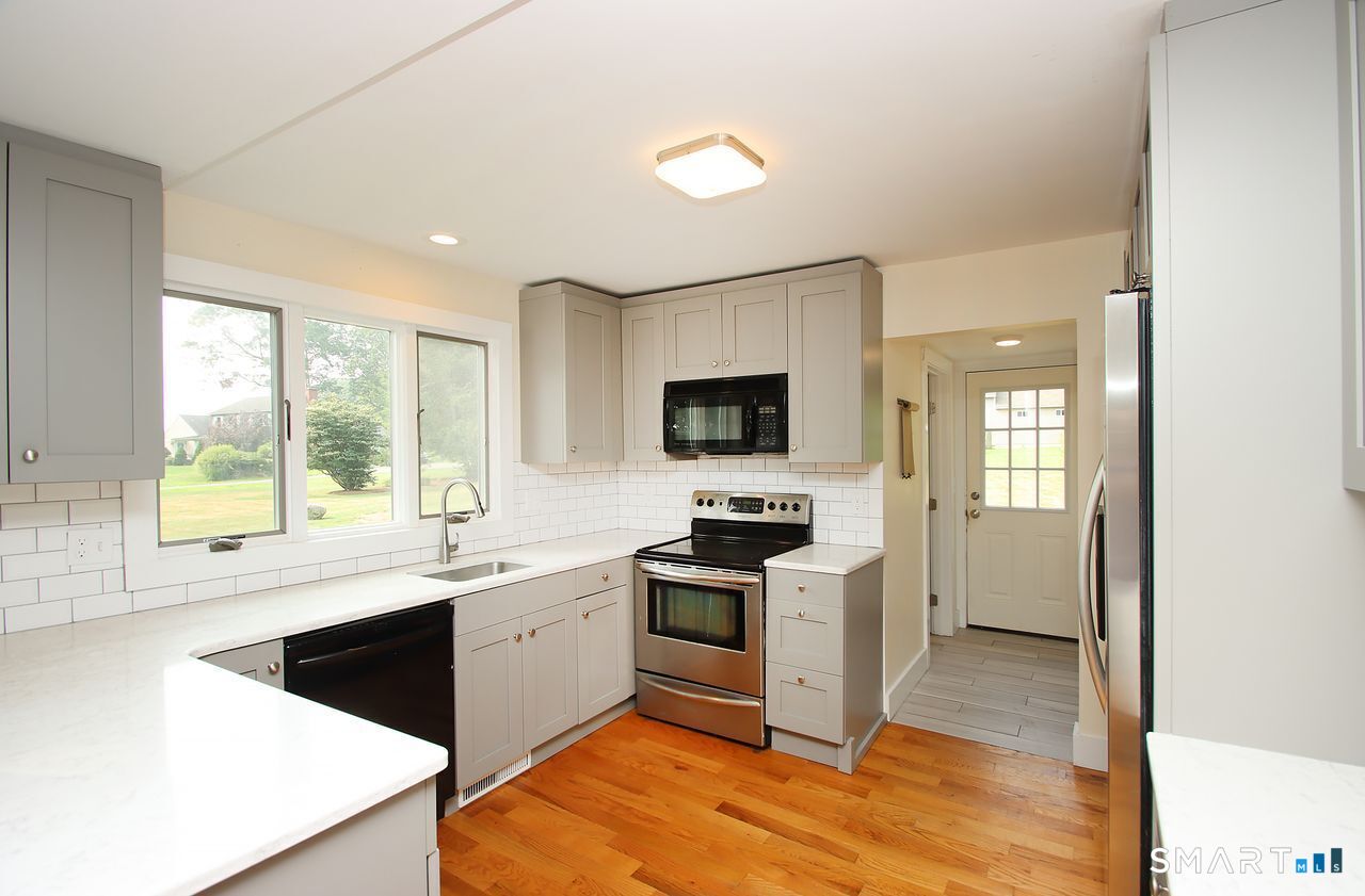 141 Duck Hole Road Madison, CT 06443 - Photo 9 of 22 a kitchen with a sink a stove and cabinets