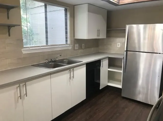 a kitchen with a refrigerator sink and cabinets