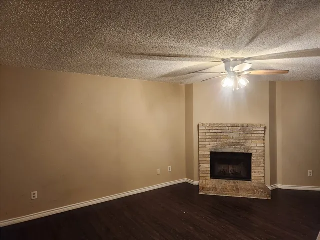 a view of a livingroom with a fireplace and a ceiling fan