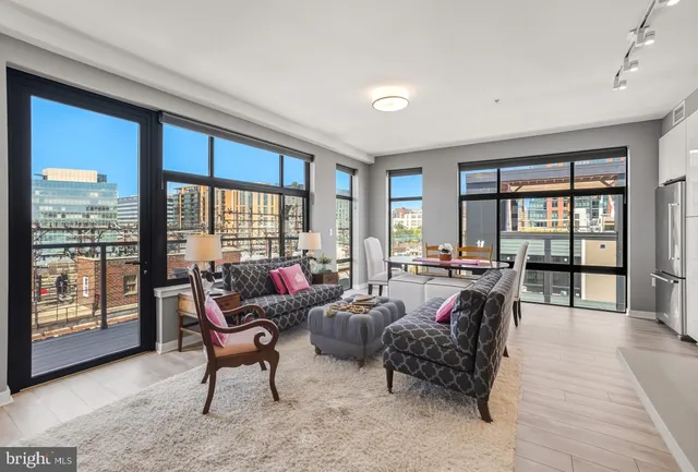 a living room with furniture and large windows