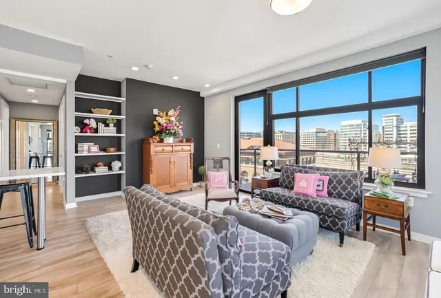 a dining room with furniture and a floor to ceiling window