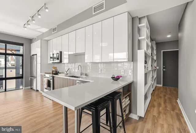 a kitchen with a table chairs refrigerator and cabinets