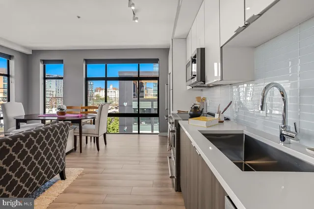 a kitchen with stainless steel appliances granite countertop a sink a stove top oven a counter space and cabinets