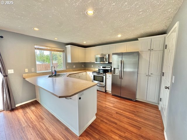 37355 Coralburst Street Sandy, OR 97055 - Photo 11 of 30 a kitchen with stainless steel appliances granite countertop a sink a refrigerator and wooden floor