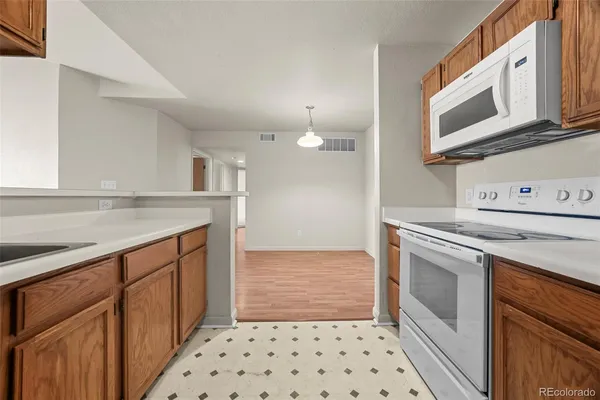 a kitchen with granite countertop a stove top oven microwave and cabinets