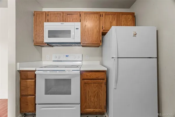 a white refrigerator freezer and a stove sitting inside of a kitchen