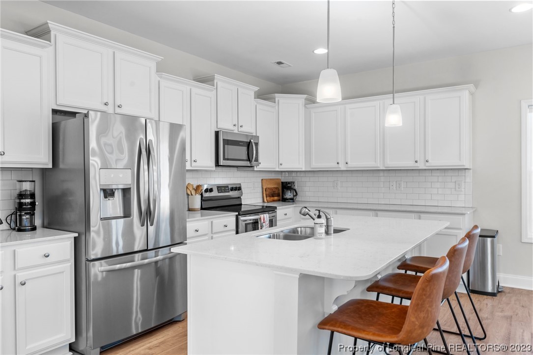 162 Old Montague Way Cameron, NC 28326 - Photo 5 of 16 a kitchen with stainless steel appliances a refrigerator a sink a stove a microwave and island