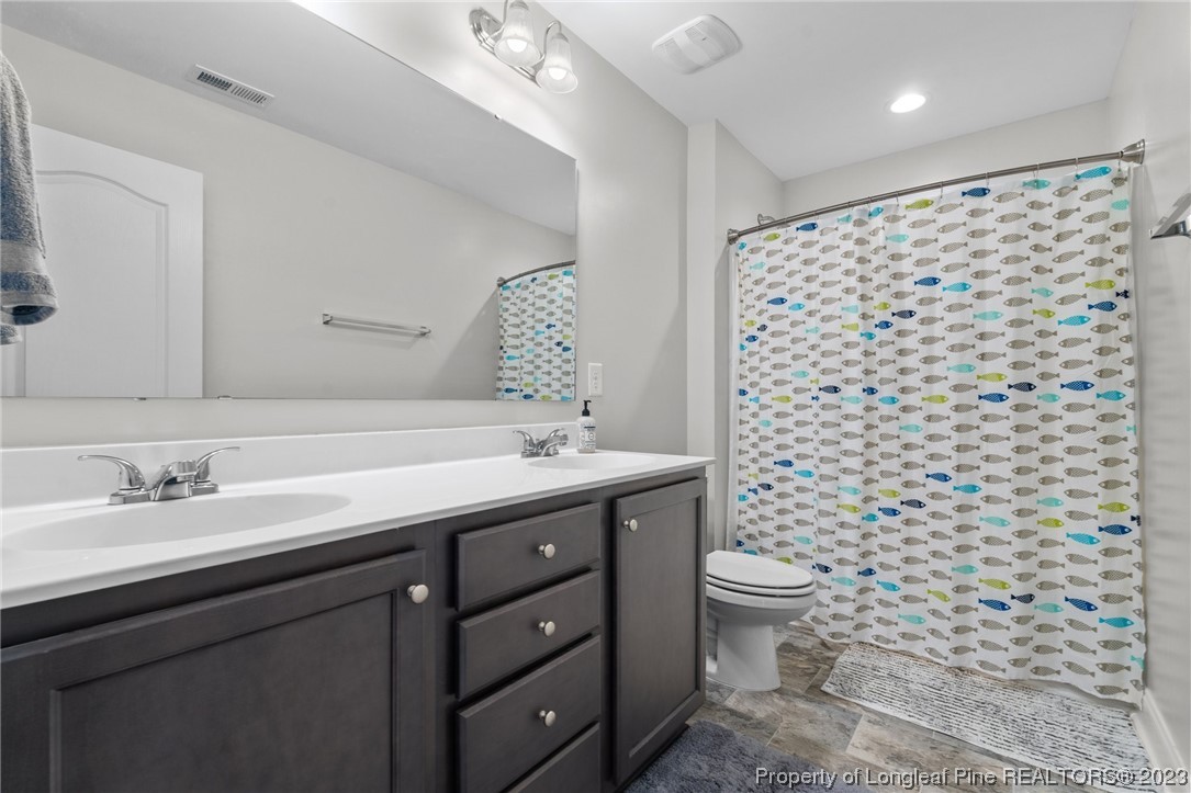 162 Old Montague Way Cameron, NC 28326 - Photo 6 of 16 a bathroom with a double vanity sink toilet and a mirror