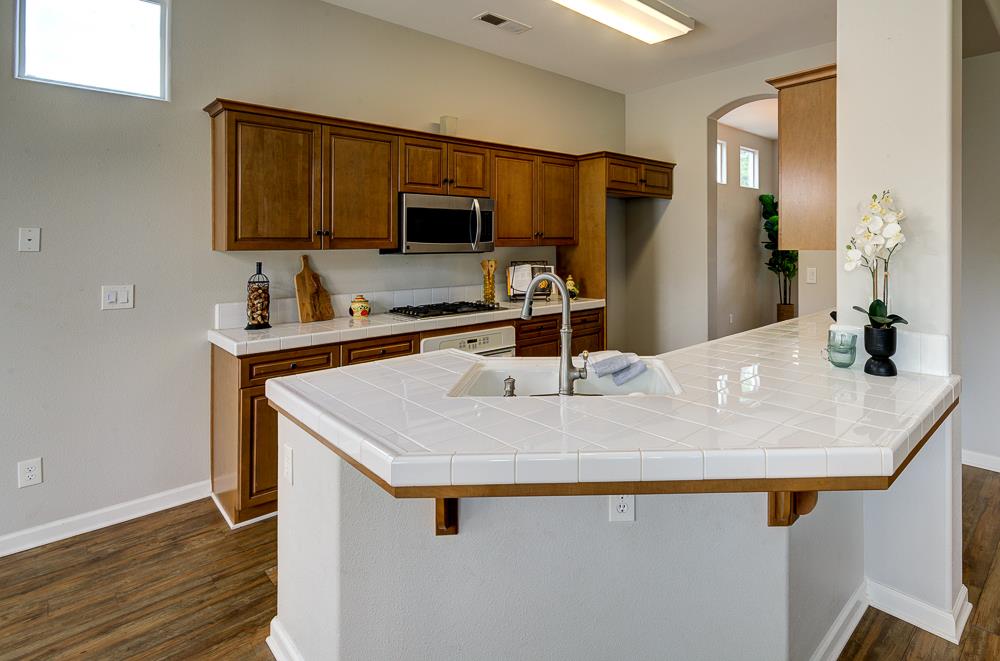 3235 Rall Avenue Clovis, CA 93619 - Photo 14 of 33 a kitchen with a sink a microwave and wooden cabinets