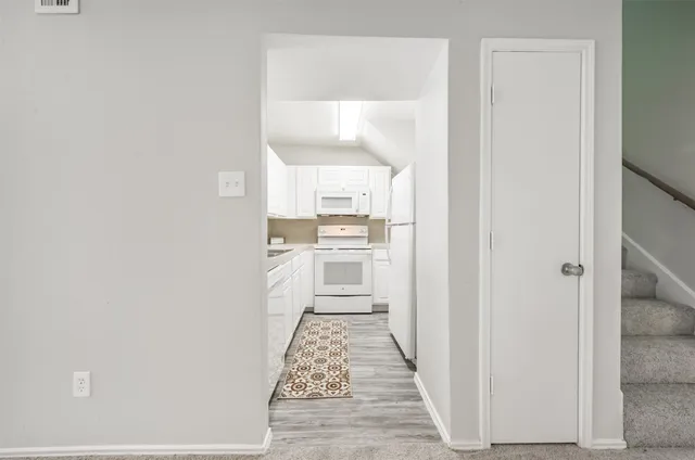 a kitchen with a refrigerator sink and white cabinets
