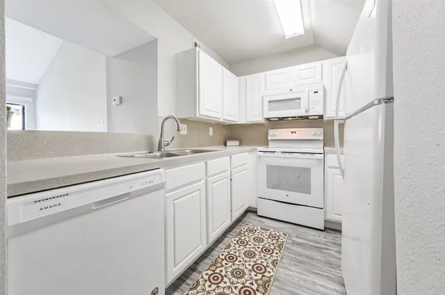 a kitchen with appliances cabinets and a sink