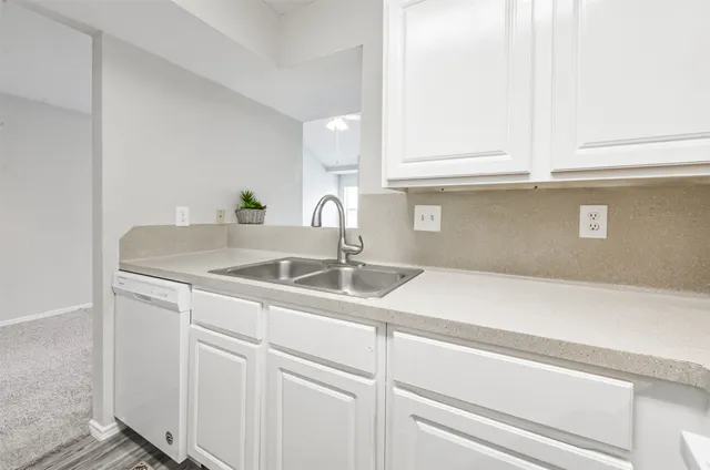 a kitchen with white cabinets and white appliances