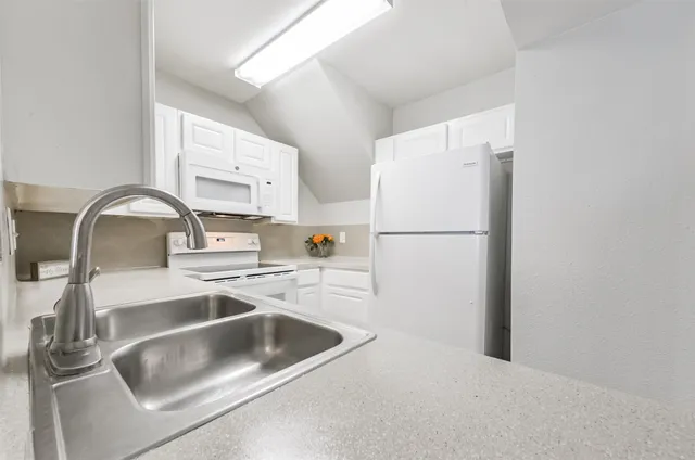 a kitchen with a stove and white cabinets