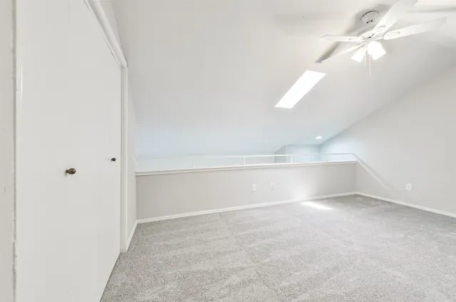 a view of an empty room with a chandelier fan