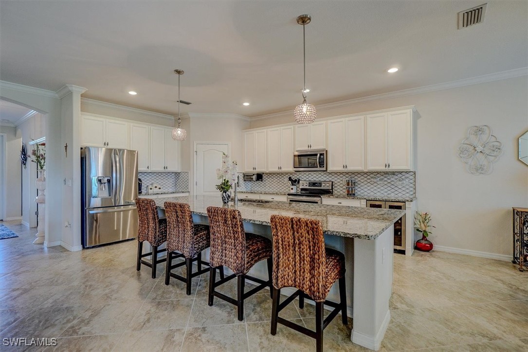 10655 Prato Drive Fort Myers, FL 33913 - Photo 11 of 49 a kitchen with stainless steel appliances granite countertop a table chairs sink refrigerator and microwave