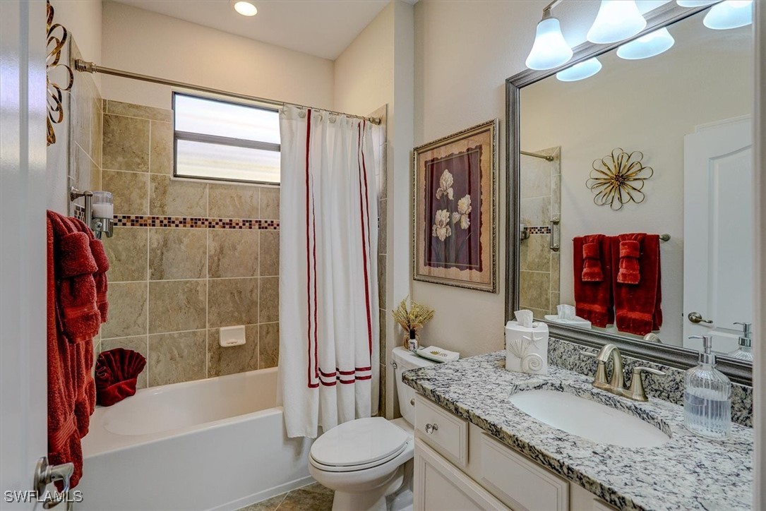 10655 Prato Drive Fort Myers, FL 33913 - Photo 28 of 49 a bathroom with a granite countertop sink a toilet a mirror a vanity a bath tub and shower
