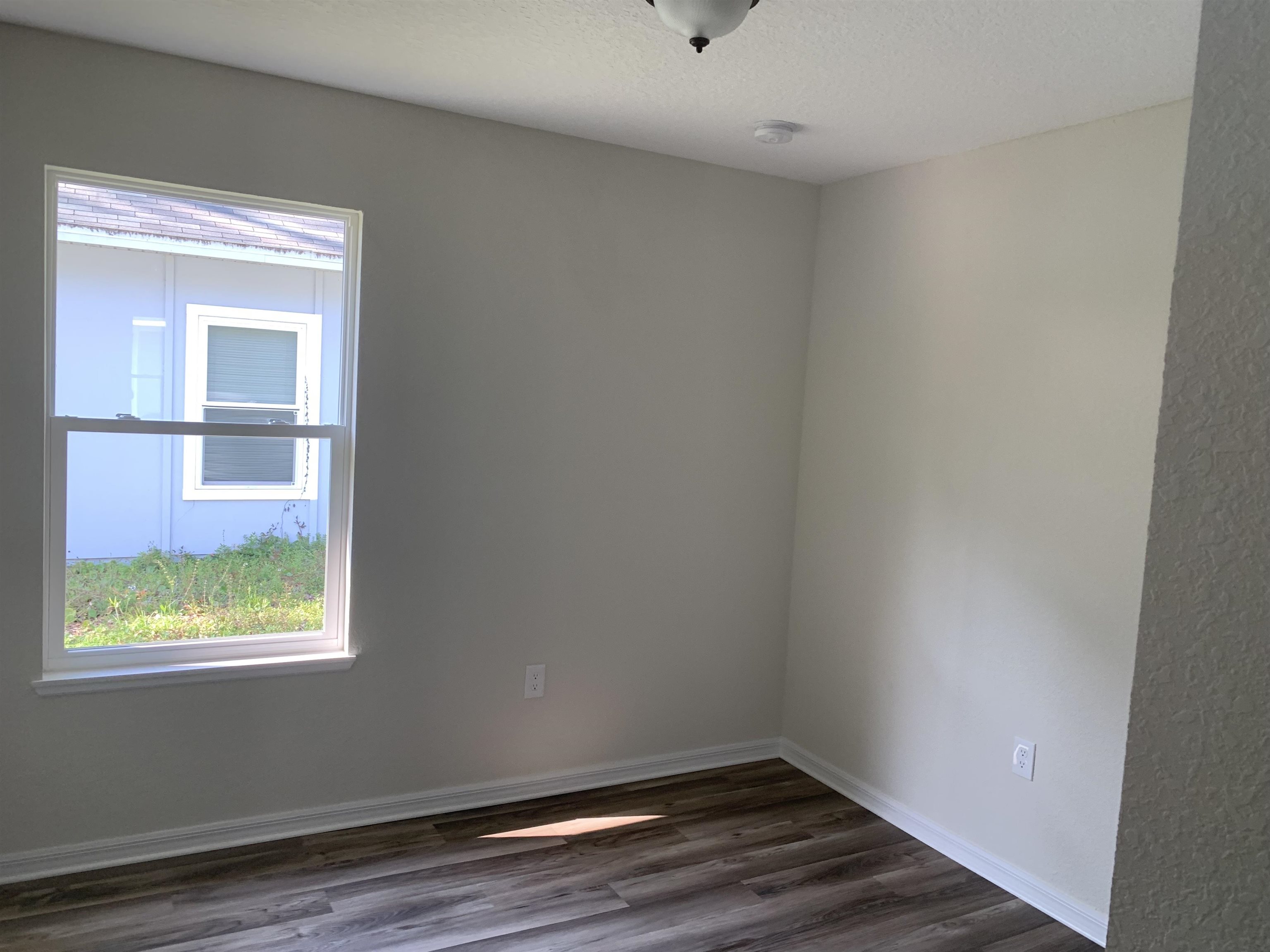 156 Gilbert Street St. Augustine, FL 32084 - Photo 29 of 35 a view of an empty room with wooden floor and a window