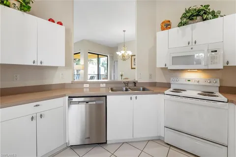 a kitchen with cabinets appliances a sink and a counter space
