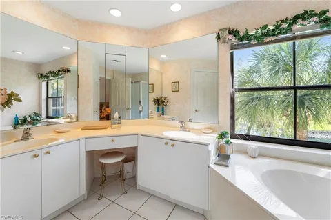 a large bathroom with a large tub sink and mirror