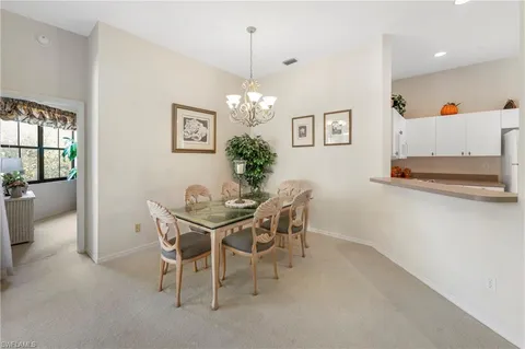 a view of a dining room with furniture and a chandelier