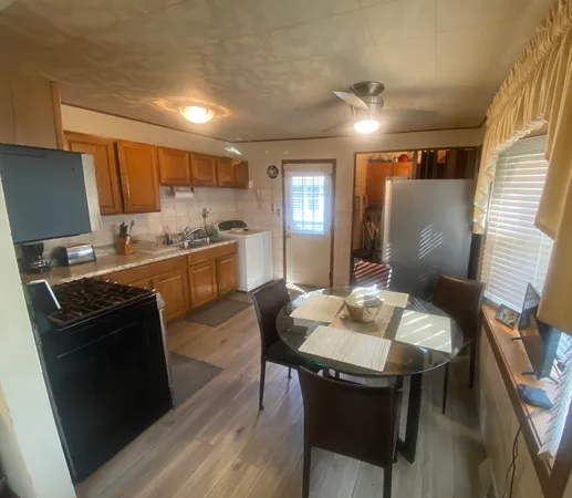 a kitchen with kitchen island a stove a table and chairs in it