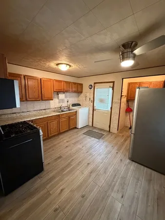 a large kitchen with stainless steel appliances granite countertop a stove and a refrigerator