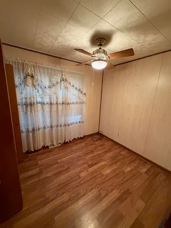 a view of an empty room with a wooden floor and a window