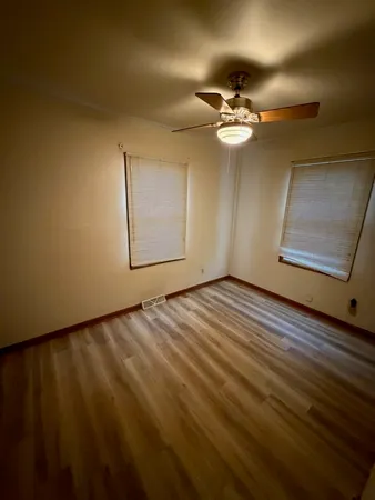 a view of a room with wooden floor and a ceiling fan