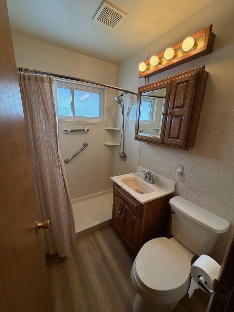 23 West 143rd Street Dixmoor, IL 60426 - Photo 29 of 30 a bathroom with a toilet sink and mirror