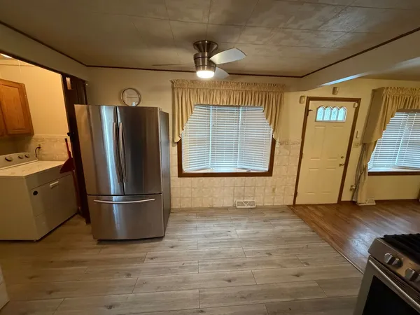 a view of a kitchen with wooden floor and stainless steel appliances